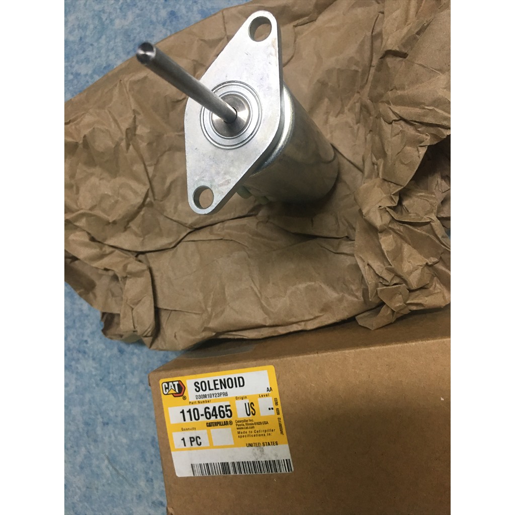 110-6465 Solenoid - mounting flange viewed above a parts carton