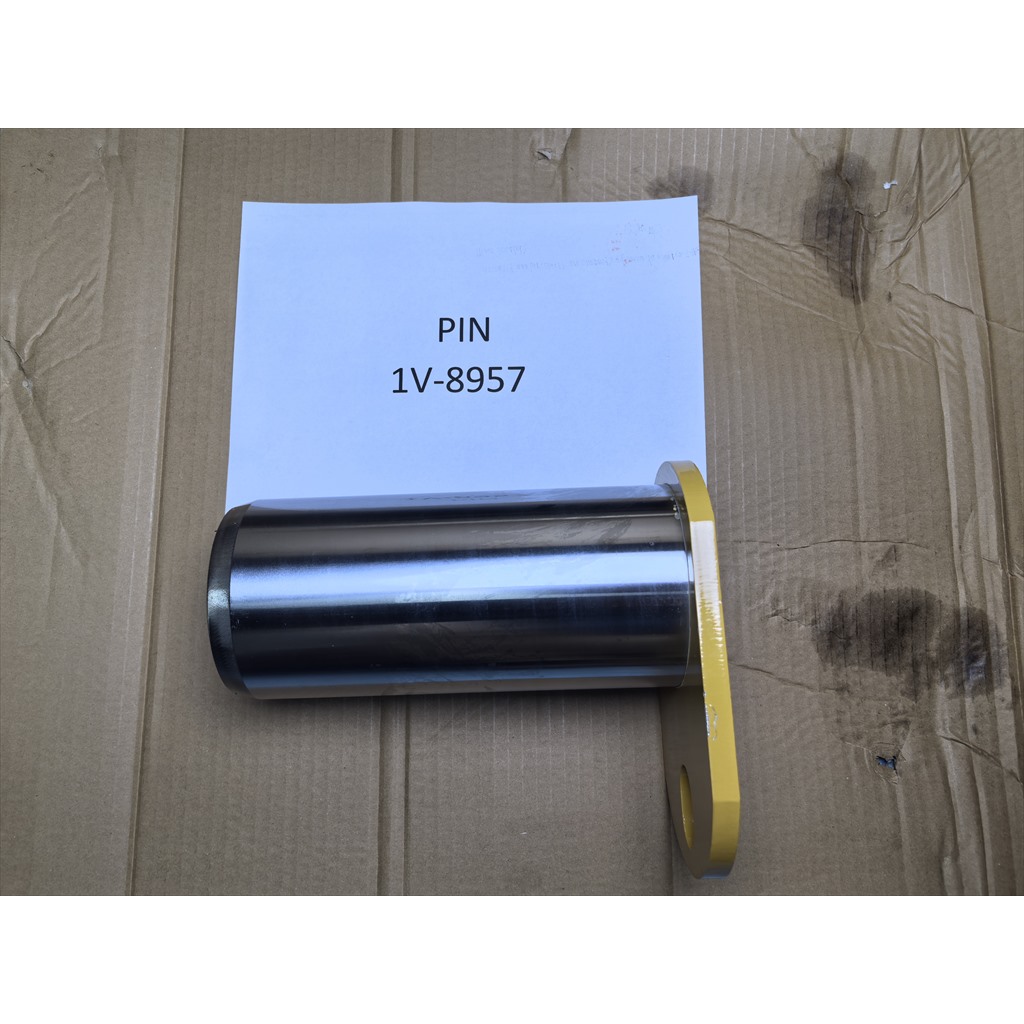 1V-8957 Pin - pin shaft laid horizontally beside an identification sheet